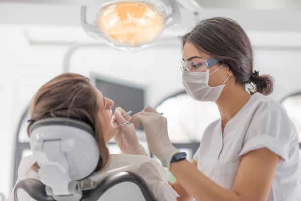 Female Dentist examining her patient in dental clinic Female Dentist examining her patient in dental clinic